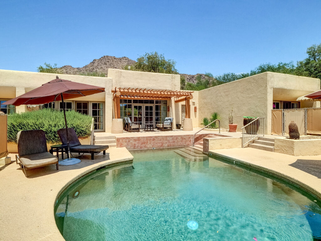 Private pool and patio shared by Units 568 and 569 at Camelback Inn with pergola seating, lounge chairs, and desert mountain views