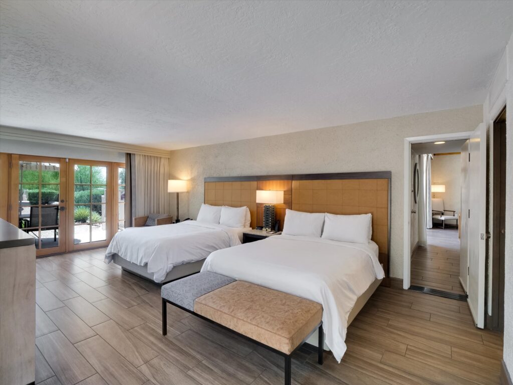Bedroom in Camelback Inn Unit 570 with two beds, wet bar, and patio access