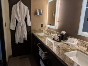 The remodeled bathroom in Unit 144 features dual granite vanities, contemporary lighting, updated fixtures, and ample storage, offering both luxury and convenience within this Camelback Inn resort residence.