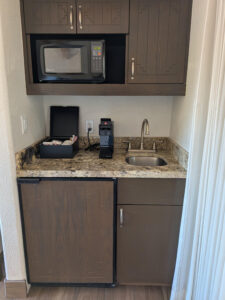 Unit 144 includes a well-appointed kitchenette featuring a wet bar, sink, microwave, coffee station, cabinetry, and refrigerator, providing added convenience for owners and guests enjoying their stay at Camelback Inn.