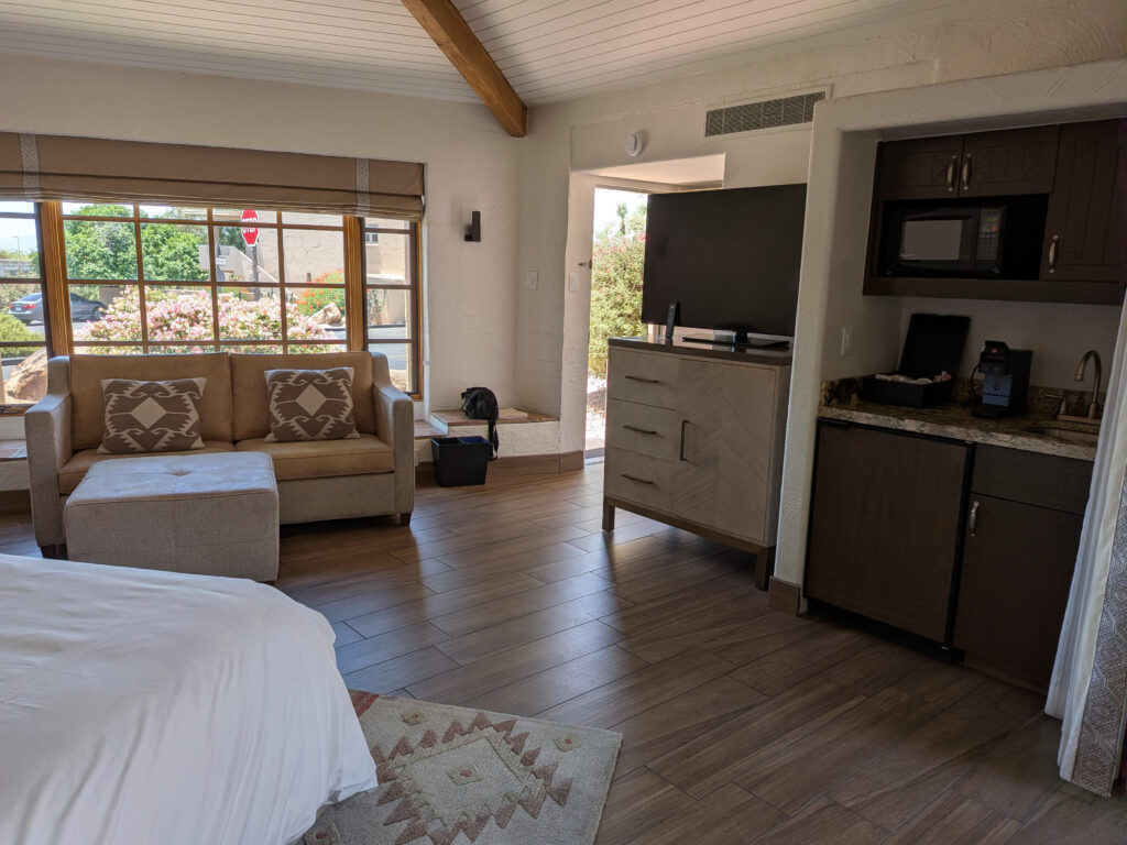Another perspective of Unit 144 highlights the spacious open floor plan, vaulted ceilings, comfortable seating area, entertainment space, and kitchenette that create a welcoming resort retreat at Camelback Inn.