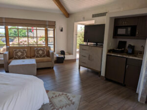 Another perspective of Unit 144 highlights the spacious open floor plan, vaulted ceilings, comfortable seating area, entertainment space, and kitchenette that create a welcoming resort retreat at Camelback Inn.